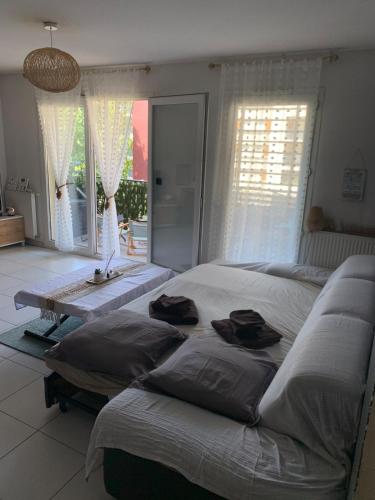 une chambre avec deux lits et une grande fenêtre dans l'établissement Calme et joie, à Montpellier