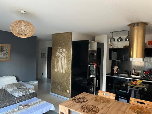 un salon avec une table et une cuisine dans l'établissement Calme et joie, à Montpellier