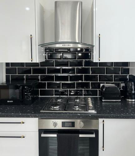 a kitchen with a stove top oven in a kitchen at Welsh Getaway Apartment 2 - Town Centre in Dowlais