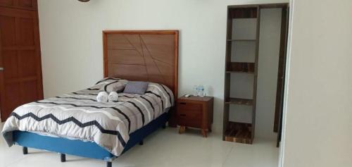 a bedroom with a bed and a dresser and a mirror at Casa Playa in Progreso