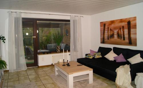 a living room with a black couch and a table at Monteurswohnung - Barlo - 4 Personen in Bocholt
