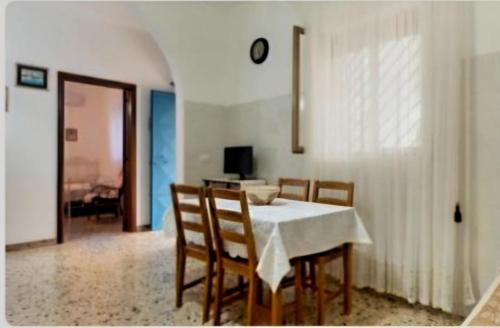 a dining room with a white table and chairs at Villa Trullo Septis in Ostuni