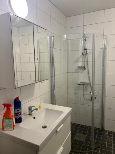 a white bathroom with a sink and a shower at Cozy double bed room in Eslöv in Eslöv