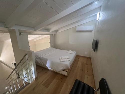 Una pequeña habitación con una cama y una escalera. en Casa Cialdini 14, en Florencia