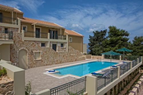 a villa with a swimming pool in front of a building at Ionian Vista Villas in Argostoli