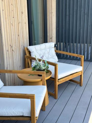 two chairs and a table on a porch at Albatross 949 by the Sea in Ķesterciems