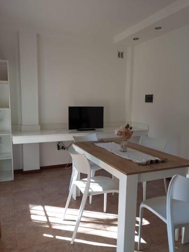 a dining room with a table and white chairs at The House II in City Bell