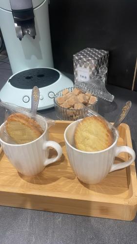 deux tasses de café et de pain sur un plateau de découpe dans l'établissement Maison La Madeleine, à La Madeleine