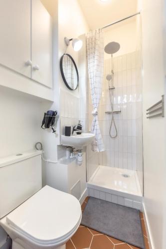 une salle de bain blanche avec des toilettes et un lavabo dans l'établissement L'Alma - Escapade d'Été à 15min de Paris & Versailles, à Garches