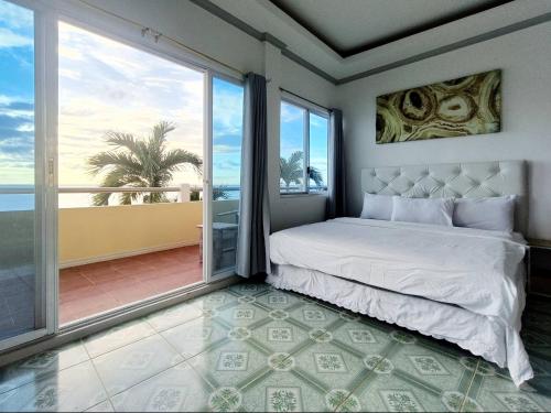a bedroom with a bed and a view of the ocean at Medellin Beachvilla 5BR | Billiard | Fiber 100Mbps in Medellin