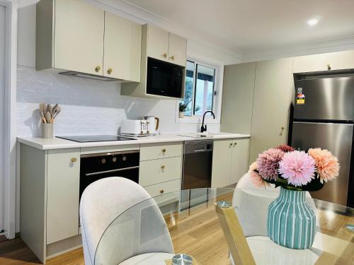 a kitchen with a vase of flowers on a table at Ann St Bungalow-Perfect Escape! in Harrington