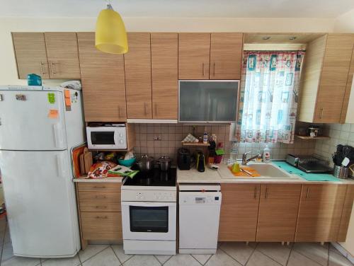 a kitchen with a white refrigerator and a sink at Villa Veta, Nikiti beach in Nikiti