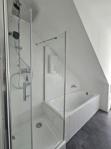 y baño blanco con ducha y bañera. en MaxMir - Ortlohn Iserlohn, en Iserlohn