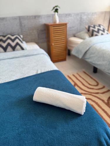 a white towel laying on a bed in a bedroom at Szumi Las Bed & Breakfast in Józefów
