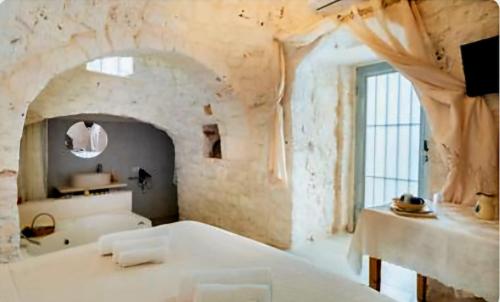 a large white bath tub in a room with a window at Villa Trullo Septis in Ostuni