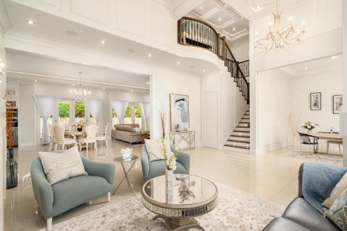 a living room with blue chairs and a dining room at Vancouver Shangrila House in Richmond