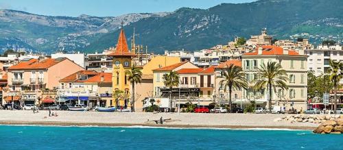 - une vue sur une plage avec des bâtiments et une ville dans l'établissement 2 pièces à 2 pas de la plage, à Cagnes-sur-Mer