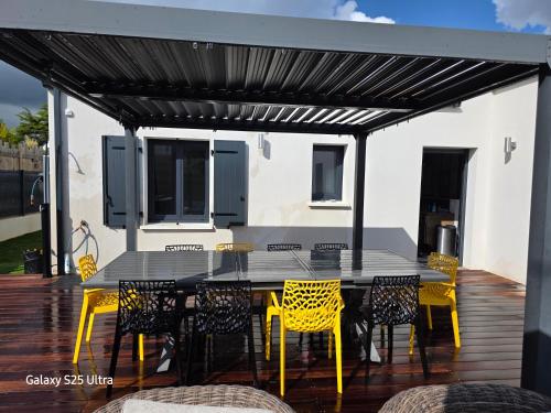 a patio with a table and chairs on a deck at Maison familiale en bord de mer avec JACUZZI in Vaux-sur-Mer