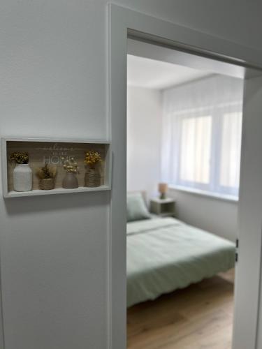 a white room with a bed and a mirror at Apartman Hanna in Dunajská Streda