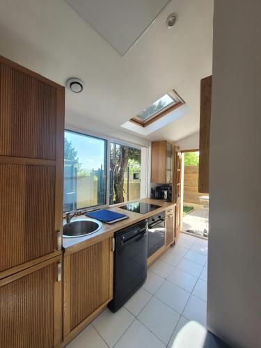 une cuisine avec un évier et une cuisinière dans l'établissement La campagne à Paris - Charmante maison à 2 pas de Paris et Versailles, à Garches