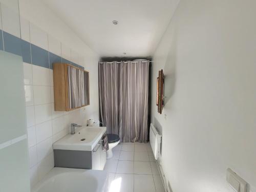 Un baño blanco con lavabo e inodoro. en La campagne à Paris - Charmante maison à 2 pas de Paris et Versailles, en Garches