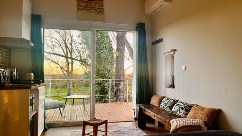 un salon avec un canapé et une porte coulissante en verre dans l'établissement Bétia Cocoon SPA et Sérénité, proche Canal du Midi, à Grisolles