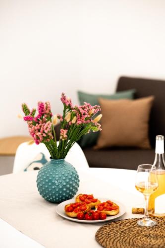a table with a vase of flowers and a plate of food at Nina Mia in Fasano