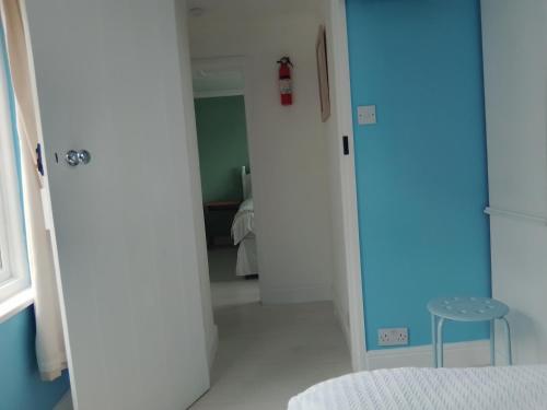 een kamer met een witte deur en een kruk bij Penzer Cottage in Mousehole