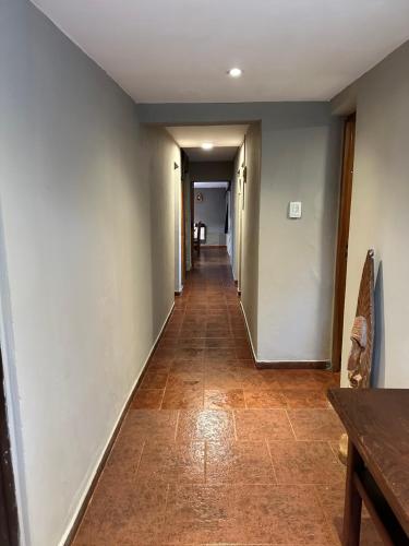 a hallway with a long corridor with a long floor and a table at Los ciruelos - Casas de Motaña in Tafí del Valle