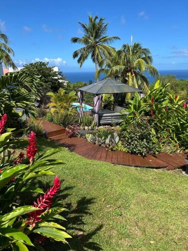 un jardín con mesa y cenador en O Soley Carib, en Saint-Claude