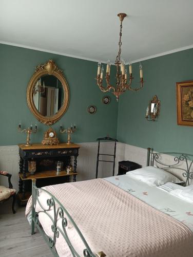 une chambre avec un lit et un miroir dans l'établissement Bel appartement, à Montluçon