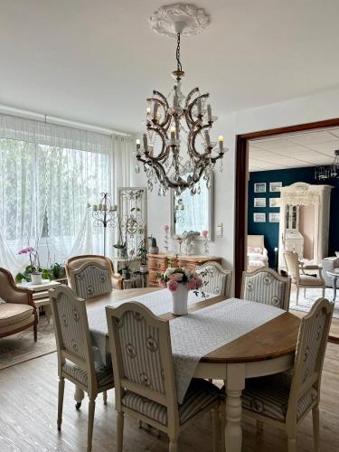 une salle à manger avec une table, des chaises et un lustre dans l'établissement Bel appartement, à Montluçon