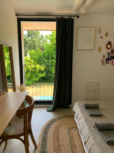 une chambre avec un lit, une table et une fenêtre dans l'établissement Maison familiale, à Soorts-Hossegor