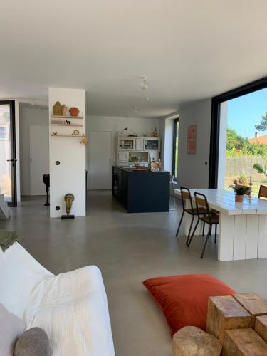 un salon avec un canapé blanc et une table dans l'établissement Maison familiale, à Soorts-Hossegor