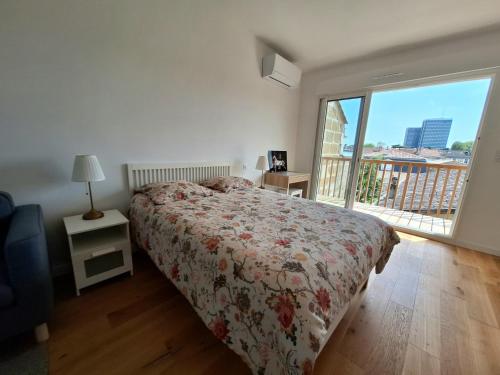 Un dormitorio con una cama y una ventana grande. en Studio 2 rénové balcon garage, en Burdeos