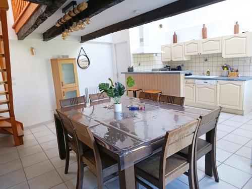 une salle à manger avec une table et des chaises dans une cuisine dans l'établissement Les grands Embruns, à Moëlan-sur-Mer