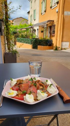 une assiette de nourriture sur une table avec un verre d'eau dans l'établissement Village house in Provence, à La Roquette-sur-Siagne