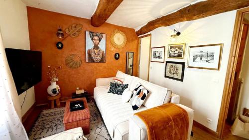 un salon avec un canapé blanc et une télévision dans l'établissement Village house in Provence, à La Roquette-sur-Siagne