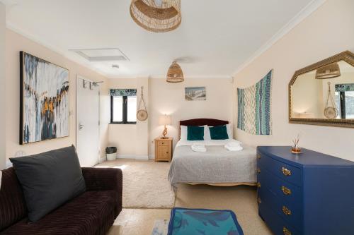 a bedroom with a bed and a couch and a mirror at Rural 7 and 2 bed Lodge stays In Windsor! Hot Tub! Sleeps 20 in Bray