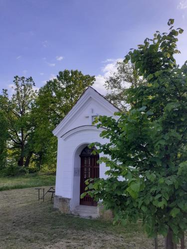 a small white building with a gate in a field at Apartmány Hluchá Bašta s vnitřním bazénem in České Budějovice