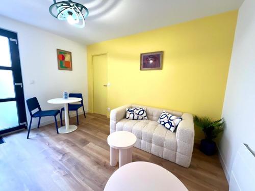 un salon avec un canapé et une table dans l'établissement Appartement le Pop Art, à deux pas du Port, au Tréport