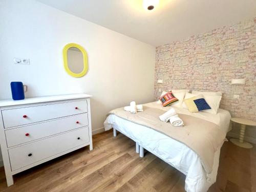- une petite chambre avec un lit et une commode dans l'établissement Appartement le Pop Art, à deux pas du Port, au Tréport