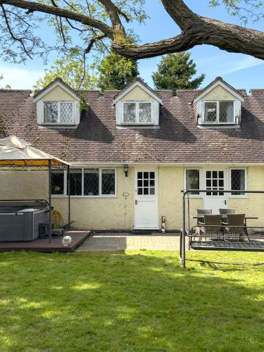 a house with a picnic table in the yard at Rural 7 and 2 bed Lodge stays In Windsor! Hot Tub! Sleeps 20 in Bray
