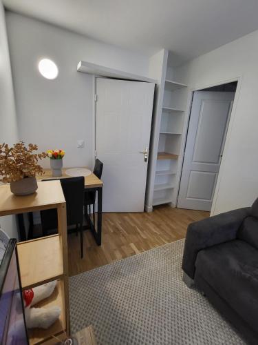 un salon avec une table et un canapé dans l'établissement Confort et parking à 10 min de Paris, à Issy-les-Moulineaux