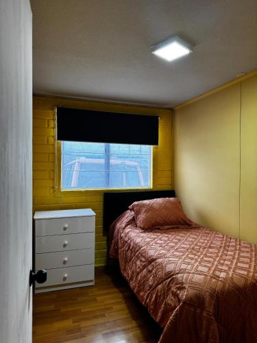 Giường trong phòng chung tại Departamento Punta Arenas a pasos del Mall