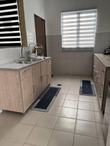 a kitchen with a sink and a tiled floor at Homestay Zailin A'Famosa in Kampong Pulau Sebang