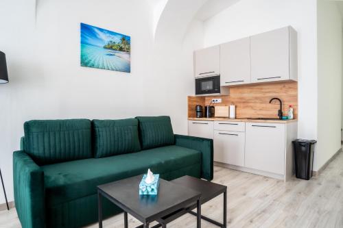 a living room with a green couch and a table at Luxapart V Beautiful Views with Breakfast in Košice