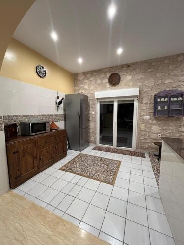 a kitchen with a refrigerator and a tile floor at Dar Éthiqua in Essaouira