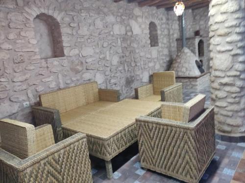 a table and chairs in a room with a stone wall at Dar Éthiqua in Essaouira