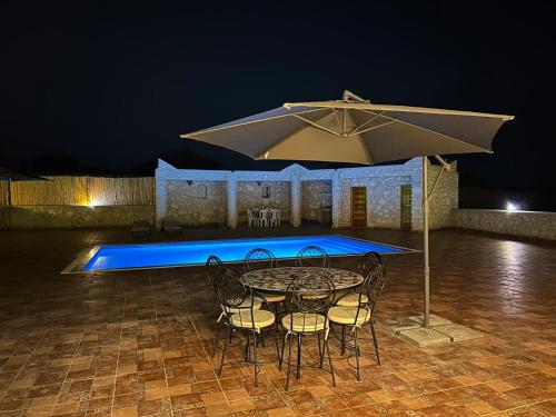 a table and chairs with an umbrella in front of a pool at Dar Éthiqua in Essaouira